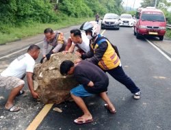 Bhabinkamtibmas Bersama Warga Bersihkan Bongkahan Batu di Jalan Trans Sulawesi